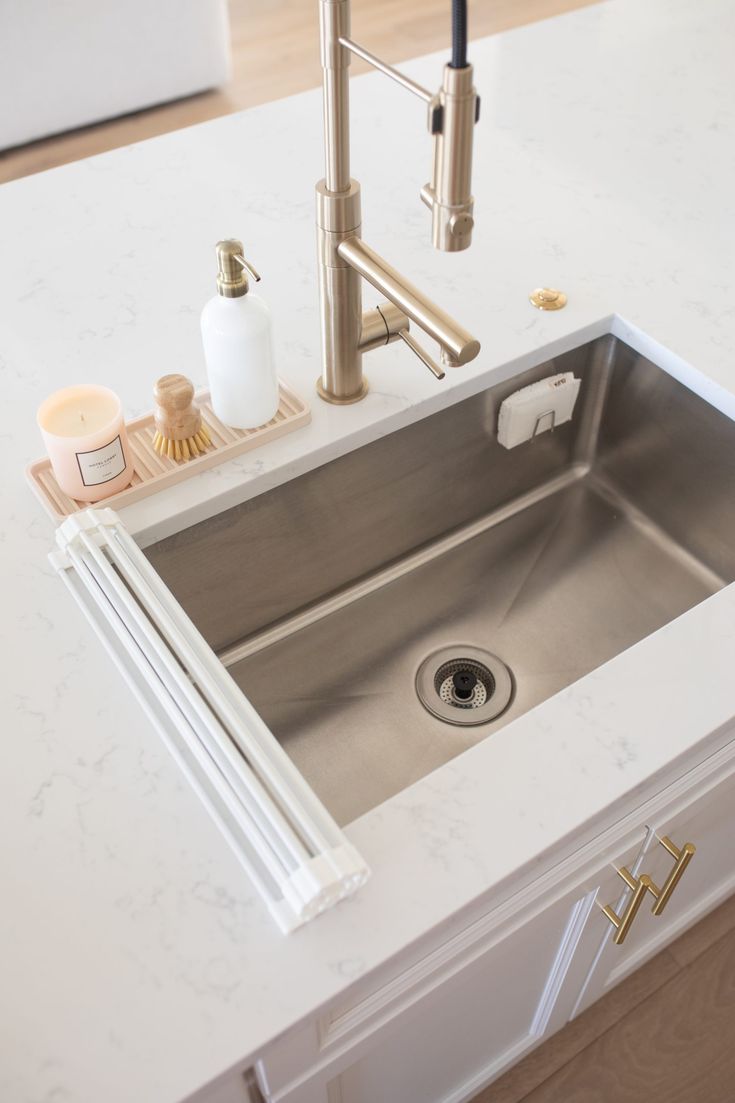 a stainless steel sink in a white kitchen