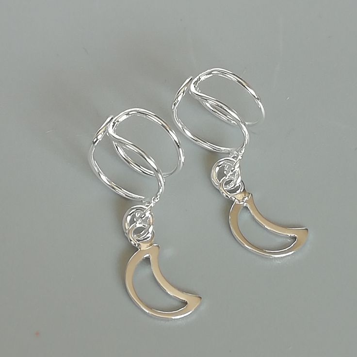 Crescent moon charm dangler, open ended sterling silver ear cuff. Dimensions: 6 x 8 mm Crescent moon: 6 x 14 Weight: 0.90gm Price listed is for ONE PIECE These are made of 925 hypoallergenic sterling silver. pieces come with a 925 stamp. Can be packaged in a gift box. I can include a personal message from you if needed You are welcome to contact me at... bhavnakwintra1956@gmail.com For more beautiful pieces from my shop, please browse 👇 TOE RINGS: https://www.etsy.com/your/shops/TheSilverGame/t Elegant Crescent Silver Cartilage Earrings, Elegant Silver Crescent Cartilage Earrings, Silver Crescent Cartilage Earrings With Moon Charm, Silver Crescent Single Cartilage Earring, Trendy Silver Jewelry With Moon Charm, Silver Moon Shaped Cartilage Earrings, Celestial Silver Wire Wrapped Earrings, Minimalist Silver Moon Phase Earrings, Trendy Silver Moon Jewelry