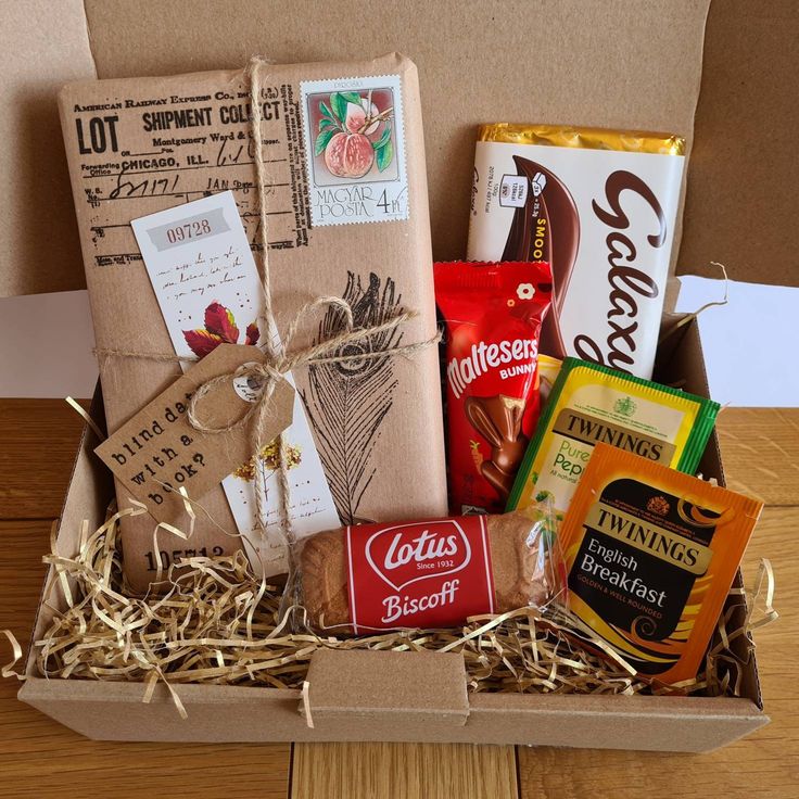 a box filled with lots of different types of food and snacks sitting on top of a wooden table