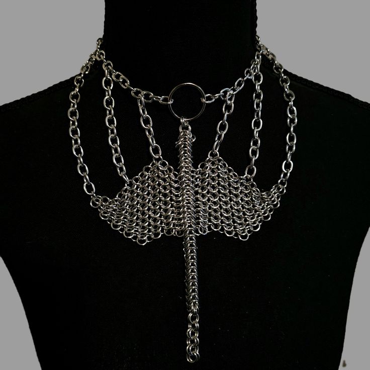 Unleash your inner dragon with the Dragon's Embrace Chainmail Necklace, a mesmerizing piece perfect for renaissance fairs and fantasy outfits. Crafted from silver anodized aluminum jump rings, this necklace features a stunning dragon intricately woven out of chainmail, showcasing exceptional artistry and detail. The Dragon's Embrace Chainmail Necklace is not just an accessory but a statement of strength, mystery, and timeless elegance. Let this unique piece adorn your neck, capturing the essence of mythical beauty and adding a touch of enchantment to your ensemble. Punk Style Metal Body Jewelry With Chain, Gothic Metal Chain Body Jewelry, Silver Punk Style Chain Body Jewelry, Silver Punk Style Body Jewelry With Chain, Silver Punk Style Body Chain Jewelry, Adjustable Fantasy Necklaces For Fantasy Events, Punk Style Silver Chain Body Jewelry, Punk Style Silver Choker For Festivals, Adjustable Fantasy Necklace For Fantasy Events