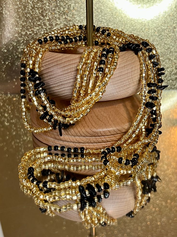 **Please allow up to 5-7 business days for processing time for Waistbeads, Free US Shipping for orders over $75 ** Our stunning Black Love Waistbeads, are perfect for adding a touch of elegance and tradition to your style. These waistbeads feature a beautiful Black and Gold throughout the waistbead. Crafted with high-quality 8/0 and 6/0 glass beads, they offer both durability and beauty. Designed to fit most with a standard length of 60", these traditional tie-on waistbeads allow you to customiz Gold Heishi Beads For Gift, Gift Heishi Beaded Necklaces With Black Beads, Unique Gold Beaded Necklaces With Spacer Beads, Traditional Gold Beads With Black Details, Gold Beaded Bracelets With Polished Beads For Festival, Gold Multi-strand Polished Beaded Bracelets, Heishi Beads Jewelry With Faceted Round Beads, Spiritual Gold Beaded Bracelet With Black Beads, Festive Gold Beaded Necklaces With Black Beads