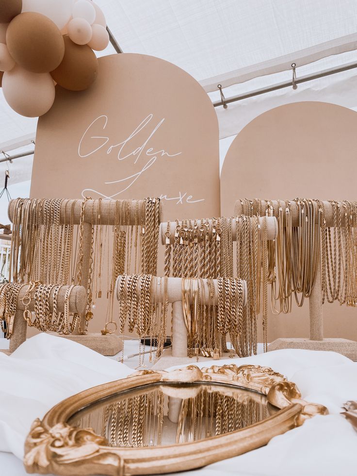 gold bracelets and necklaces are on display under a tent