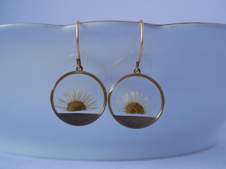 These small round brass frames that are evocative of the sun on the horizon hang from 24k gold plated ear hooks. Available in your choice of real preserved botanical: Queen Anne's Lace is a symbol of sanctuary The Daisy is a symbol of hope Forget-me-nots are known as a symbol of lasting friendship, love, and remembrance Materials are tarnish resistant. However, please see our care section for info on keeping your piece lovely for years to come. All materials are nickel and lead free. Ships in a Nature-inspired Nickel Free Round Earrings, Nickel-free Round Nature-inspired Earrings, Nature-inspired Hoop Earrings As Gift, Nature-inspired Round Hoop Earrings For Gift, Pierced Yellow Gold Flower Earrings, Pierced Round Yellow Gold Flower Earrings, Yellow Gold Pierced Flower Earrings, Gold Circle Earrings In Sterling Silver, Yellow Gold Round Pierced Flower Earrings