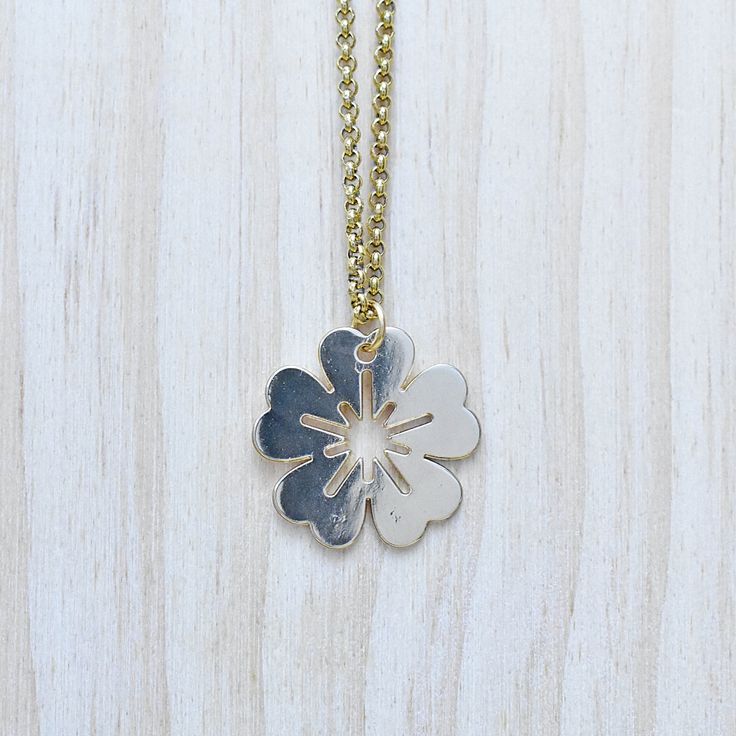 This necklace is made from a flower coin charm. The charm is gold plated and has a very shiny surface. The necklace is finished off with a gold plated stainless steel chain. You can choose the style and length of the chain. Please choose the length you would like the necklace in. Please choose the chain style you would like your pendant on. Please note that all necklaces are handmade and may differ from the pictured. The picture shows multiple necklaces. You will receive one necklace with one pe Yellow Gold Flower Charm Necklaces, Yellow Gold Flower Necklaces With Charms, Yellow Gold Flower-shaped Necklaces With Charms, Yellow Gold Flower-shaped Necklace With Charms, Yellow Gold Flower Charm Necklace With Round Pendant, Gold Charm Necklace With Flower Charm, Silver Medallion Necklace With Flower Charm, Gold Round Pendant Flower Necklace With Birth Flower, Gold Round Pendant Birth Flower Necklace