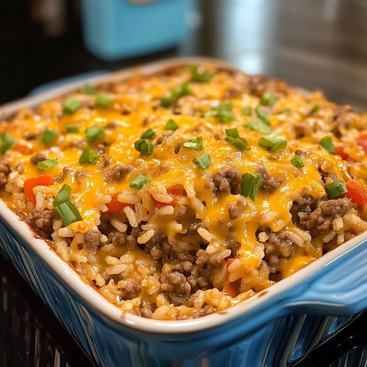 a casserole dish filled with ground beef, rice and veggie toppings