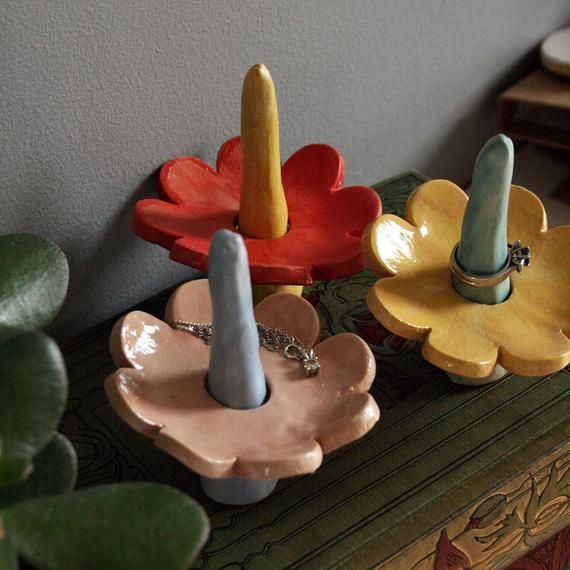 three ceramic flower shaped dishes sitting on top of a table