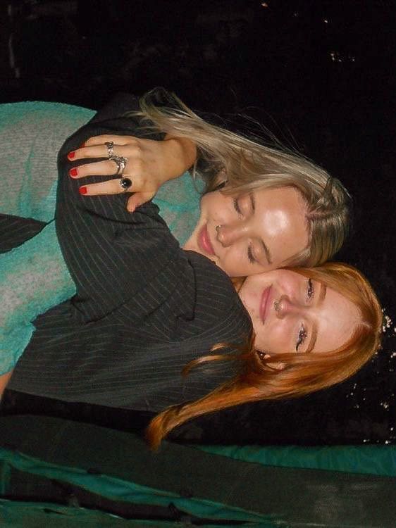 two women are hugging each other in the dark