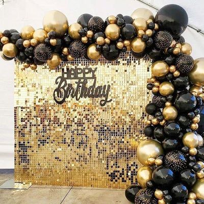 a black and gold birthday party with balloons in the shape of an arch that says happy birthday