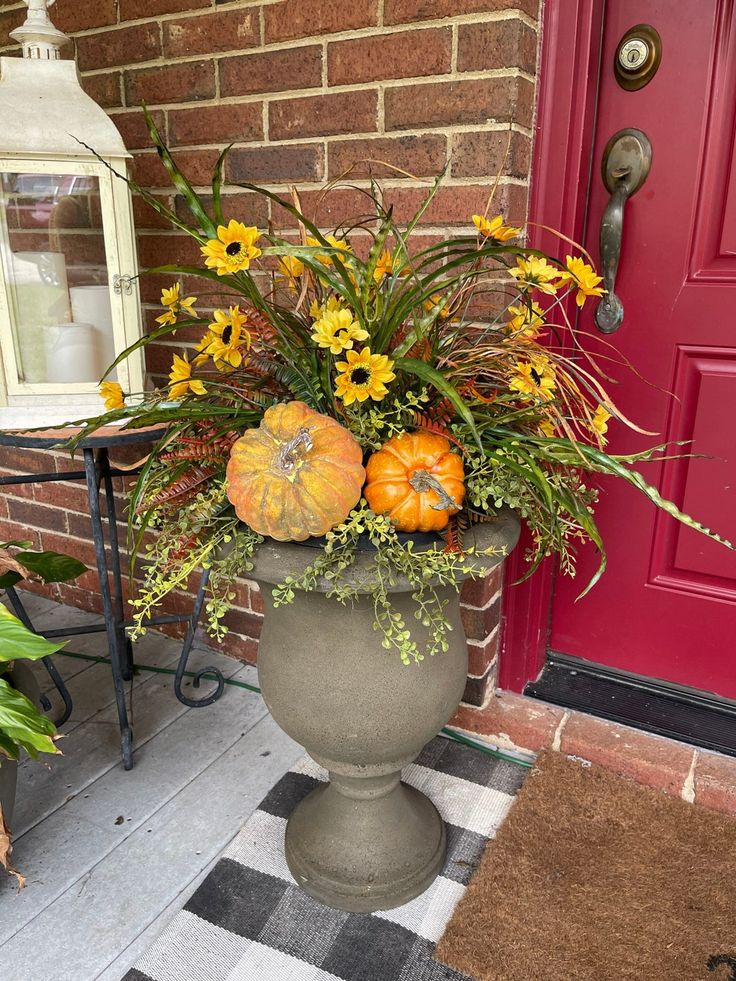 a potted planter filled with flowers and pumpkins