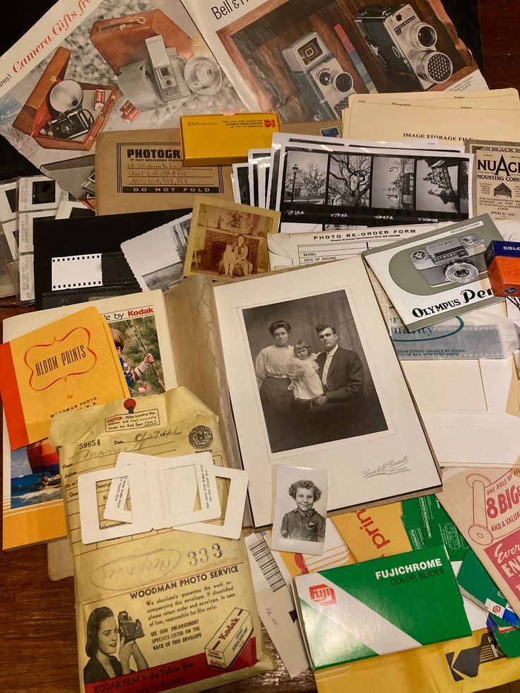 an assortment of old and new items are on the table together, including books, photos, and pamphlets