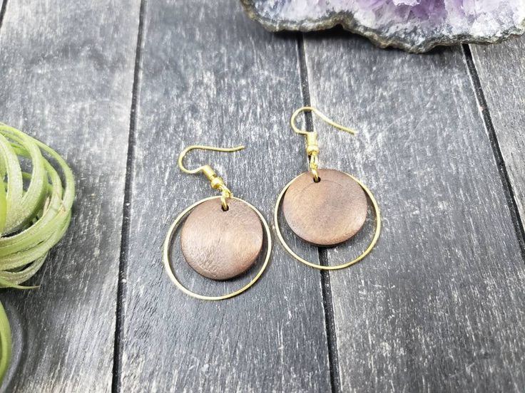 "These lightweight dangle earrings feature 18mm dark brown unfinished wooden discs dangling inside 25mm gold plated brass hoops. The ear wires are made of hypoallergenic gold plated surgical steel, making these earrings safe for sensitive ears! They are super lightweight, each weighing only 0.1 ounce. They measure approximately 1.75 inches from the top of the ear wires to the bottom of the gold hoop. Domestic shipping is always free here at Mayamadethis! When will my item ship? Every single item Brown Circular Earrings As Gift, Brown Circular Earrings For Gifts, Brown Circular Earrings For Gift, Hypoallergenic Brown Round Earrings, Brown Round Earrings For Pierced Ears, Everyday Brown Wood Earrings, Round Wooden Earrings As Gift, Round Wooden Earrings For Gifts, Wooden Round Earrings For Gifts