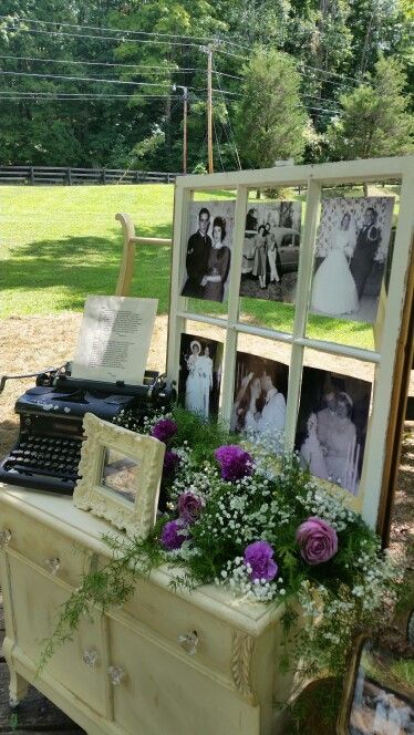 an old typewriter with flowers and pictures on it sitting in front of a table