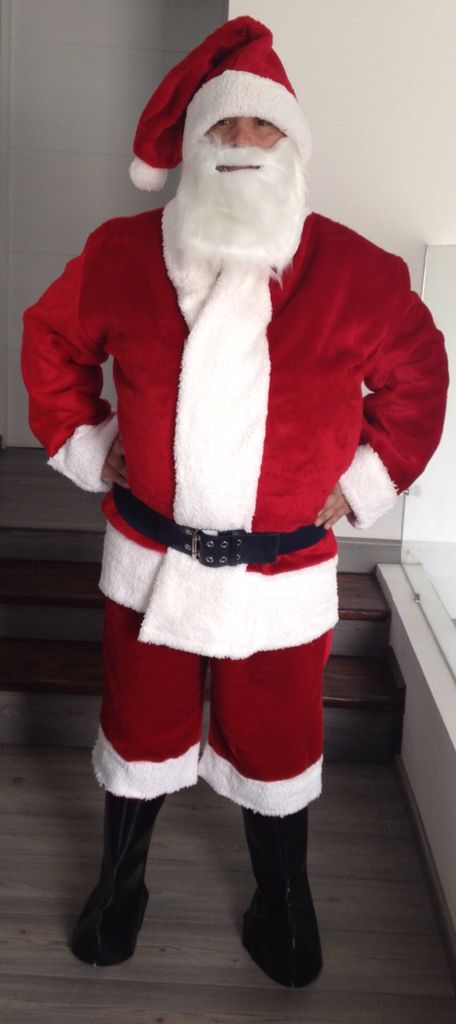 a man dressed as santa claus standing in a room