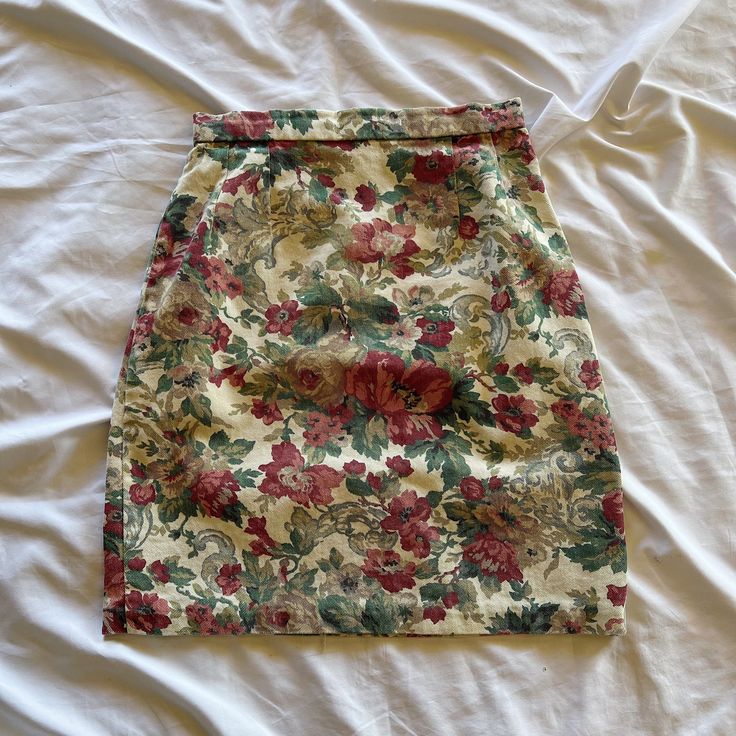 Vintage 90s handmade denim floral skirt. Fits a size 2 or 25" waist. No stretch. Zips up the back. Most likely cotton. Care: Machine washable. Measurements Waist: 25" Hips: 36" Length: 20" High Waist Fitted Floral Print Mini Skirt, Fitted High-waist Floral Print Mini Skirt, Fitted High Waist Floral Print Mini Skirt, Fitted Floral Print High Waist Mini Skirt, Fitted Retro Cotton Mini Skirt, Retro Fitted Mini Skirt With Floral Print, Retro Fitted Floral Mini Skirt, Vintage Fitted Cotton Skirt, Floral Print Pencil Mini Skirt