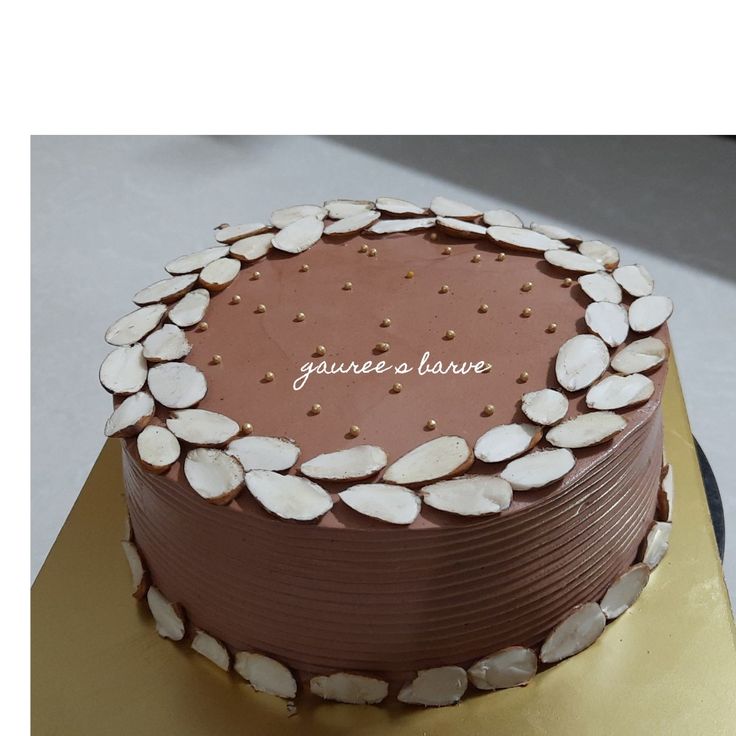 a chocolate cake with white and gold decorations