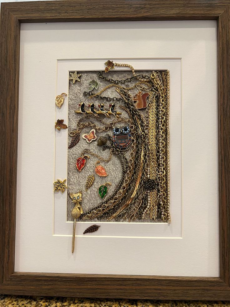 an art work is displayed in a wooden frame with beads and other things on it