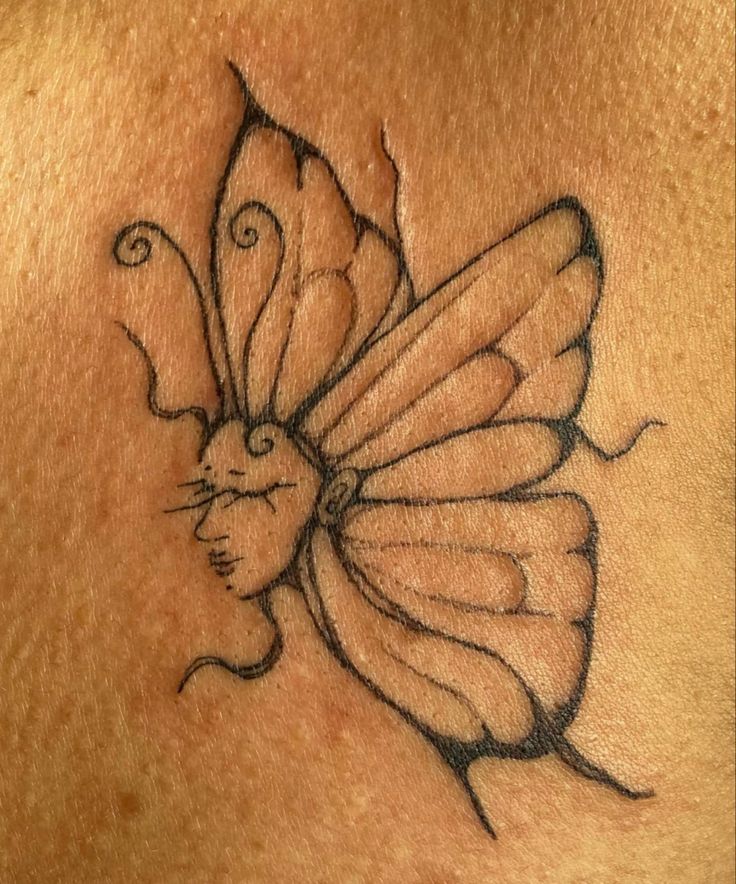 a woman's chest with a butterfly tattoo on it