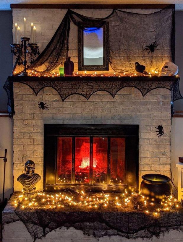 a fireplace decorated with halloween decorations and lights