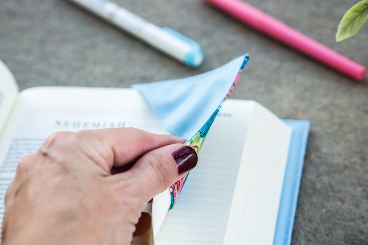 a person is holding an open book and writing on it