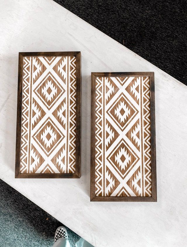 two brown and white wooden boxes sitting on top of a table