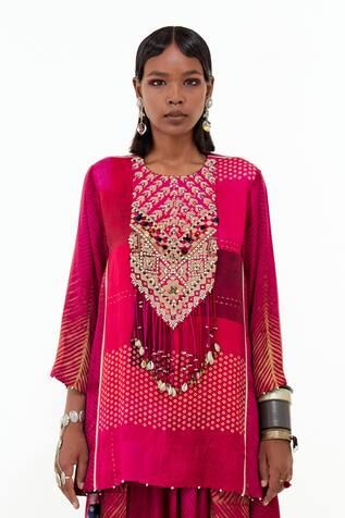 Shocking pink short kurta with all over mixed print, contrast aari, shell, sequin, tassel, mirror and bead embroidered tribal pattern yoke and drop tassel details. Paired with printed pleated cowl draped trouser.
Components: 2
Pattern: Printed and Embroidered
Type Of Work: Mixed Print, Aari, Shell, Sequin, Tassel, Mirror and Bead Work
Neckline: Round Neck
Sleeve Type: Full Sleeves
Fabric: Mushroom Twill, Cotton Silk
Color: Pink
Other Details: 
Beaded kurta hem
High-low kurta
Shell and bead tasse Traditional Straight Kurta Blouse With Mirror Work, Bohemian Palazzo Set With Motifs For Festive Occasions, Traditional Wear Straight Kurta With Dupatta For Festival, Bohemian Kurta With Gota Work For Navratri, Bohemian Gota Work Kurta For Navratri, Bohemian Kurta With Gota Work, Bohemian Palazzo Set With Mirror Work And Straight Kurta, Bohemian Blouse Piece With Cutdana For Navratri, Bohemian Palazzo Set With Motifs For Festive Season