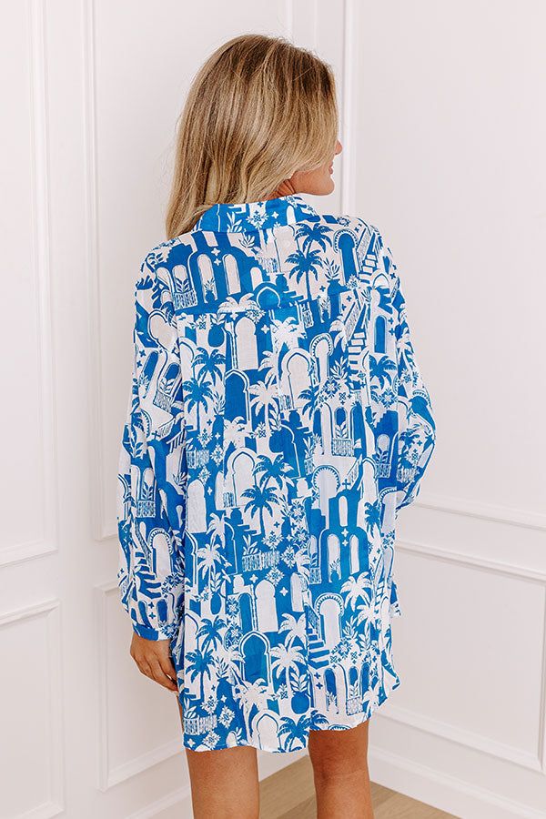 - Add a touch of the tropics to your wardrobe with this chic button-up! With its lightweight material and tropical-themed print, this piece is perfect for a walk down a breezy boardwalk. Whether you're heading to a beachside cafe or enjoying a sunset cruise, this shirt brings a vacay vibe to any occasion. - Unlined semi-sheer lightweight material with an abstract tropical cityscape print - A collared neckline - A button up front - Long sleeves with button closure cuffs - Functional chest pockets Summer Button-up Hawaiian Shirt For Beach, Summer Hawaiian Button-up Shirt For Beach, Beach Hawaiian Shirt With Button Closure, Hawaiian Shirt With Button Closure For Beach, Summer Hawaiian Button-up Beach Shirt, Button-up Hawaiian Shirt For Beach Season, Palm Tree Print Button-up Hawaiian Shirt For Beach, Palm Tree Print Button-up Beach Tops, Beach Hawaiian Shirt With Relaxed Fit