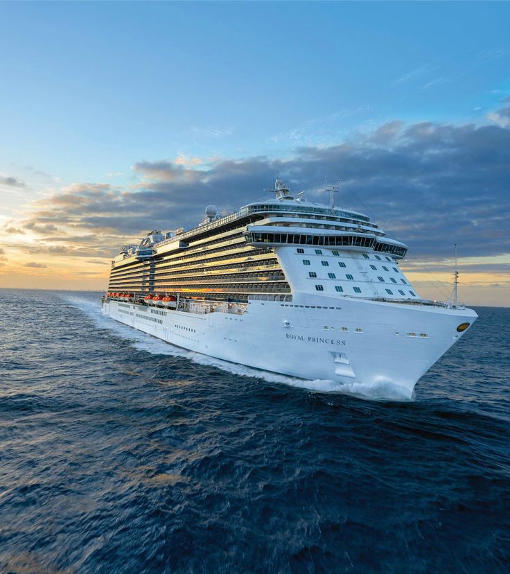 a cruise ship sailing in the ocean at sunset