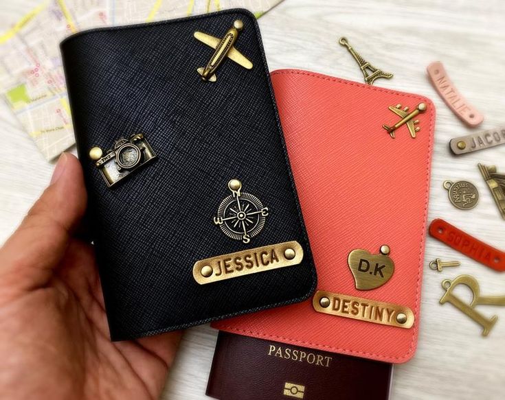 two passport covers with gold lettering on them, one is black and the other is red