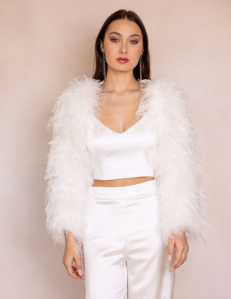 Make a statement with our elegant and luxurious ostrich feather sleeves. Crafted with the finest materials, these sleeves are a true work of art, perfect for any special occasion. These gorgeous sleeves are made of soft and fluffy up-cycled ostrich feathers, providing a glamorous and eye-catching look that will leave a lasting impression. They are connected with a satin ribbon, making it reversible and allowing you to tie the bow in the front or the back depending on your preference. With a soft Chic Long Sleeve Feathered Outerwear, Elegant Fitted Feathered Outerwear, Elegant Fitted Feather Outerwear, Party Outerwear With Feather Trim And Faux Fur, Elegant Faux Fur Outerwear For Night Out, Chic Fitted Feathered Outerwear, Elegant Winter Feathered Outerwear, Fitted Feathered Formal Outerwear, Elegant Spring Outerwear With Feathers