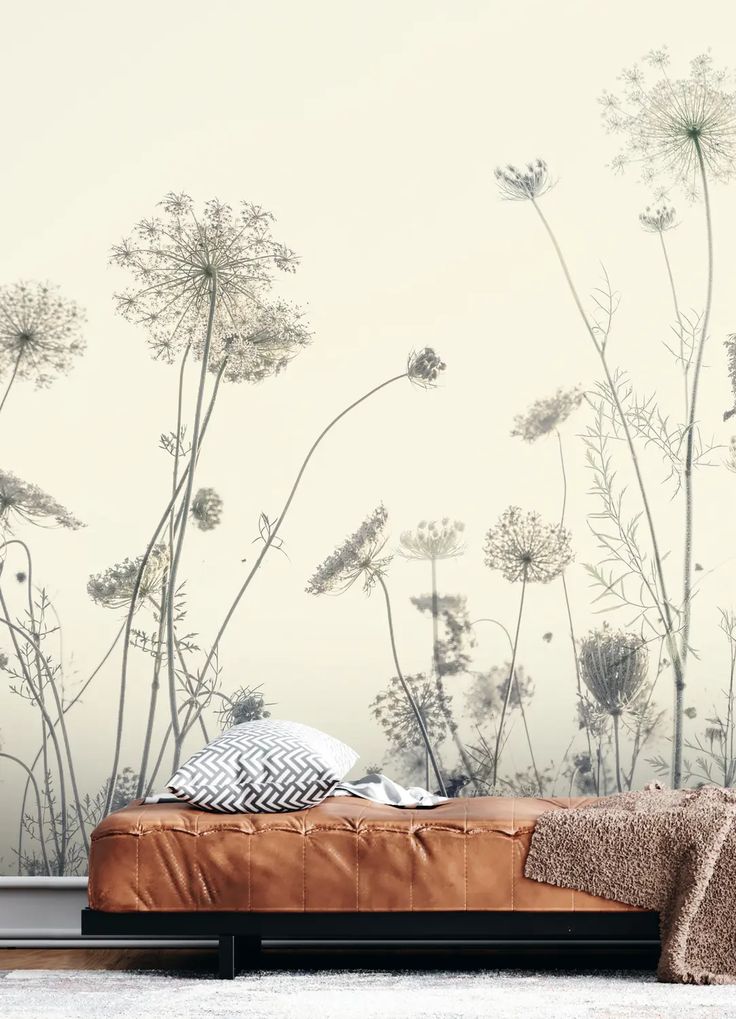 a bed sitting in front of a wall with flowers on it