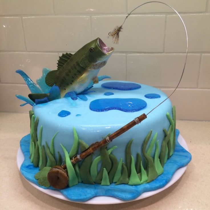 a cake decorated to look like a fishing scene with fish on the top and rod in the middle