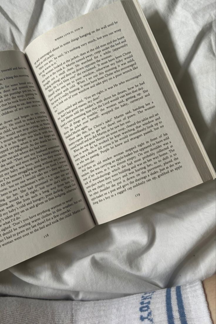 an open book sitting on top of a bed