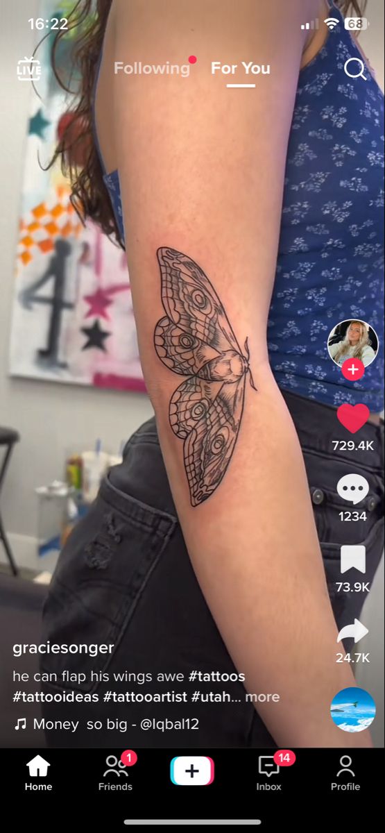 a woman's arm with a butterfly tattoo on the left side of her arm