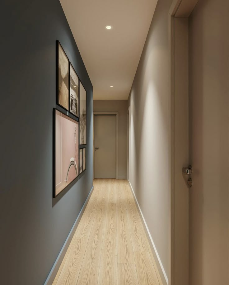 an empty hallway with framed pictures on the wall