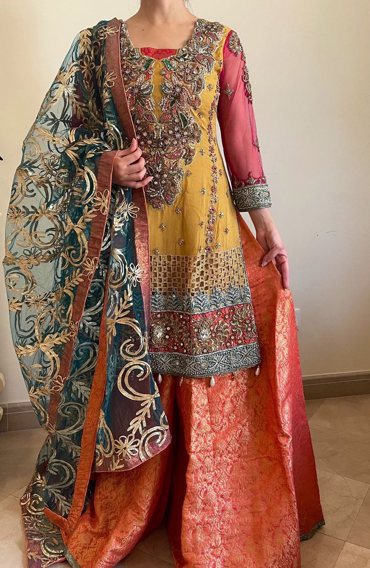 Representing ethnic clothing, handmade in Pakistan. This is the perfect bridal outfit! Comes with - Multi colored Shirt filled with handwork. - Jamawaar Sharara in tea pink. - Gota dupatta in green.  We do not accept returns/exchanges. Please allow slight color and design variations. Gharara Dress, Bridal Gharara, Bridal Outfit, Stunning Outfits, Hand Work, Bridal Outfits, Dress Clothes For Women, Designer Collection, Latest Design