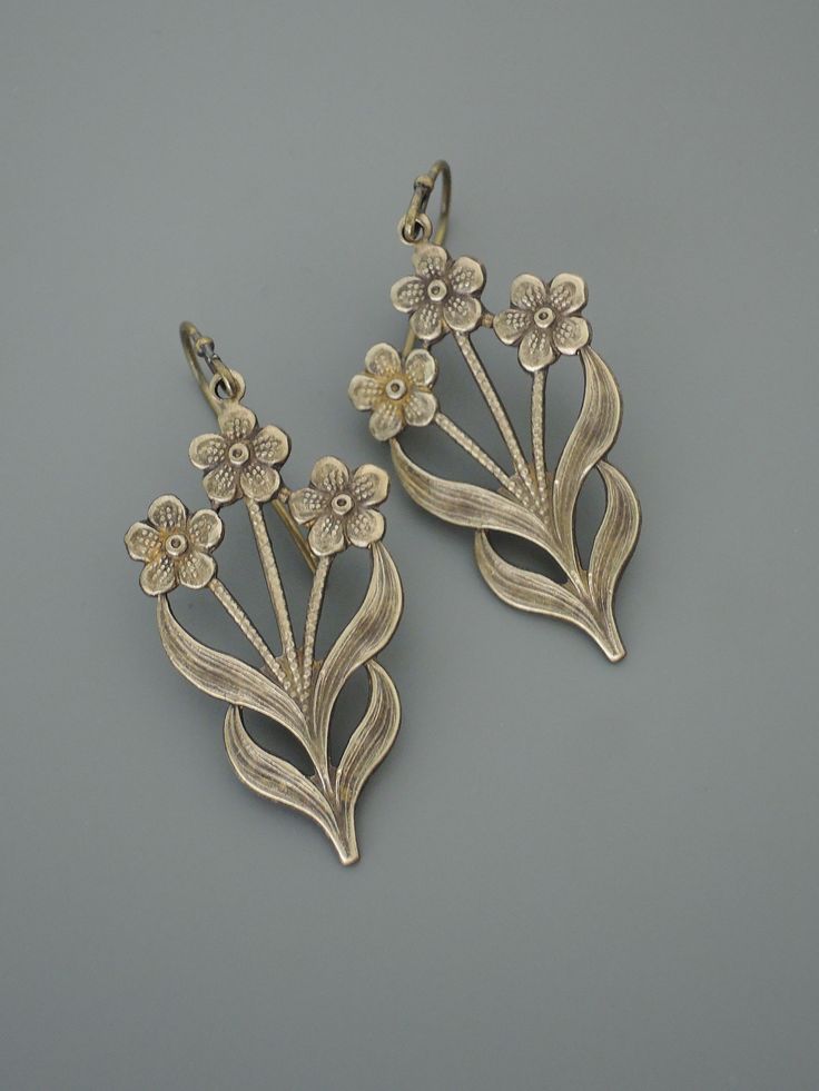 "Vintage Jewelry - Vintage Earrings - Flower Earrings - Flower Jewelry - Brass Earrings - Chloe's Vintage handmade jewelry Such pretty earrings! Vintage brass floral design drops. Would make nice Bridesmaids earrings. Chloe says, \"Wear them and feel fabulous!\" They measure 1 3/4\" long from the top of the ear wire Thanks for visiting Chloe's" Pierced Metal Drop Flower Earrings, Brass Flower Earrings For Wedding, Metal Pierced Flower Earrings, Silver Flower-shaped Brass Earrings, Flower Shaped Brass Wedding Earrings, Flower-shaped Brass Wedding Earrings, Vintage Metal Flower Earrings For Pierced Ears, Silver Pierced Brass Flower Earrings, Silver Brass Flower Earrings, Pierced