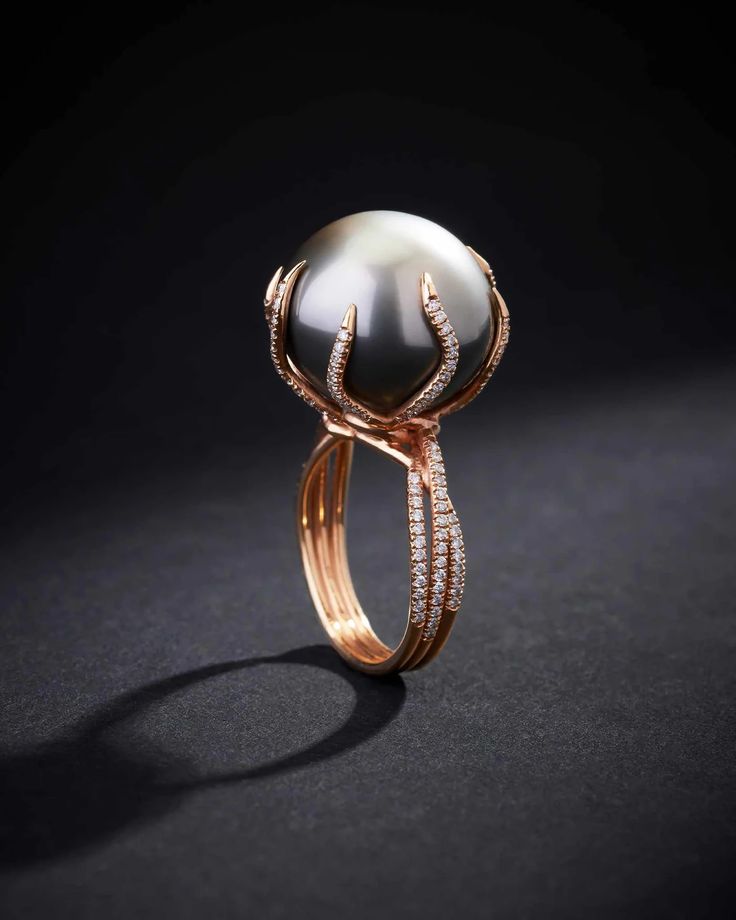 This ring perfectly encapsulates the ethereal beauty of a Tahitian pearl, renowned for its luminous sheen and captivating allure. This one-of-a-kind ring is not just a jewelry piece but a work of art. Cradling the pearl are delicate crescents of rose gold, reminiscent of the tender arms of a crescent moon, each meticul Beautiful Jewelry Pearl, Luxury Formal Rings With Pearl Drop, Luxury Round Rings For Jewelry Making, Unconventional Engagement Rings Pearl, Black Pearl Diamond Ring, Pearl High Jewelry Ring, Pearl And Diamond Ring Modern, Unusual Rings Pearl, Tahitian Pearl Ring Unique