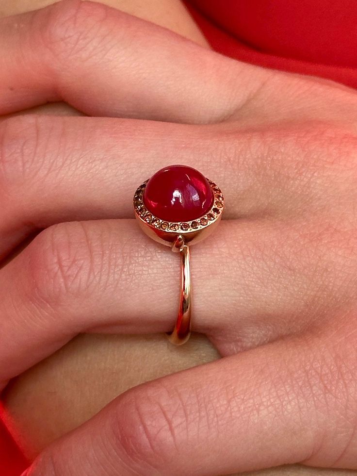 Breathtaking in its classic simplicity and timeless design, this vibrant eye catching ruby cabochon with a subtle sheen is accentuated with a pave of sparkling fancy cognac red diamonds. Alone or stacked with the rings from our collection,it is absolutely perfect. Ruby cabochon 11mm Diamonds size 1.1mm 9K solid rose gold Follow us on Instagram: https://www.instagram.com/missionewyork/ Ruby Ring Cabochon, Luxury Red Cabochon Ruby Ring, Luxury Ruby Ring With Cabochon Cut, Luxury Ruby Ring Oval Cabochon Polished Finish, Luxury Cabochon Ruby Ring For Anniversary, Luxury Ruby Ring Oval Cabochon With Polished Finish, Luxury Ruby Ring With Oval Cabochon And Polished Finish, Elegant Round Cabochon Ruby Ring, Formal Cabochon Domed Ruby Ring