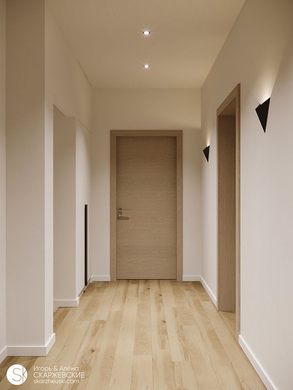 an empty room with wooden floors and two lights on either side of the door that is open