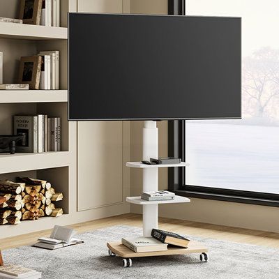 a flat screen tv sitting on top of a wooden stand in front of a window