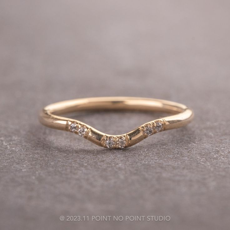 a gold wedding band with three diamonds on it