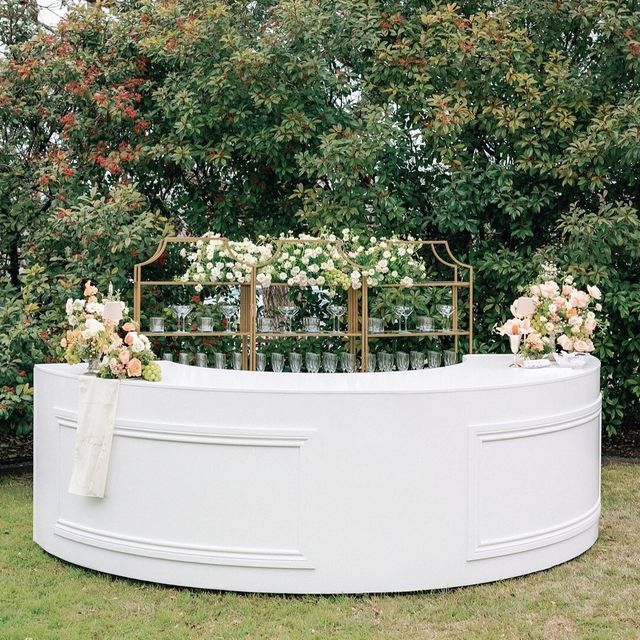 an outdoor ceremony setup with white flowers and greenery