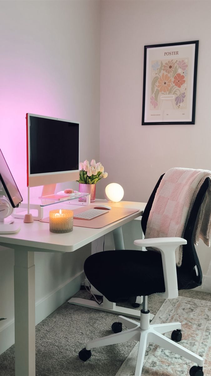 a white desk with a computer on it and a pink light in front of it