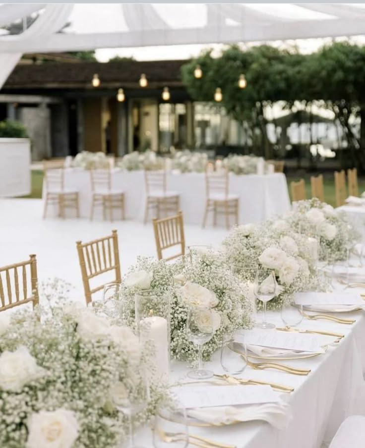 the tables are set with white flowers and candles