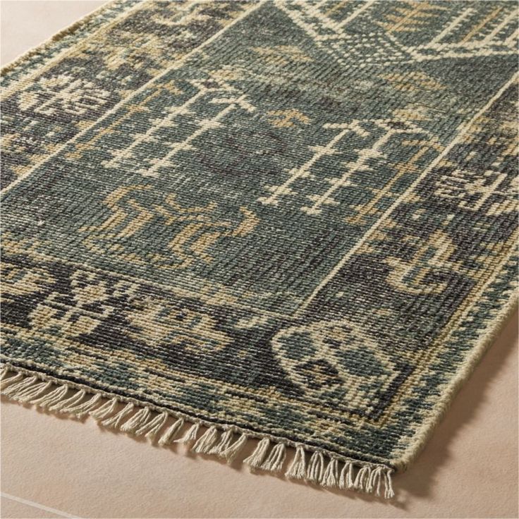 Crafted by hand of New Zealand wool, hand-knotted area rug features a pattern in shades of smoked green, beige and black. Vintage effect is created through a process of oxidized washing and gentle distressing. Durable flatweave construction is suitable for high-traffic areas. Due to the distressing and hand-knotting processes, each will be unique. CB2 exclusive.How will it look in your room? 12andamp;quot;x12andamp;quot; rug samples are available in stores for a fee refundable upon return of the 8’ Round Rug, Rugs In Living Room Green, Rug For Green Couch, Entry Way Rugs Foyers, Green Area Rugs In Living Room, Entryway Runner Rug Ideas, Rug Combinations, Kitchen Runner Rug Ideas, Layered Cowhide Rug