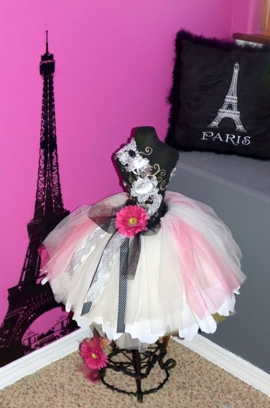 there is a dress and hat on display in front of the eiffel tower