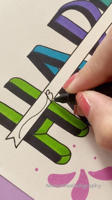 a woman's hand writing the word happy on a piece of paper with a marker