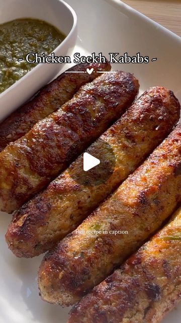 grilled sausages on a white plate with green sauce