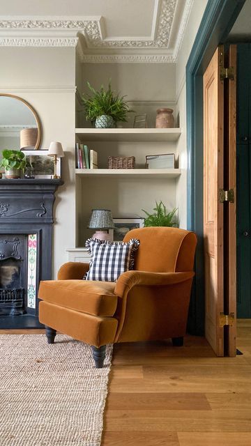 a living room filled with furniture and a fire place next to a fireplace covered in potted plants