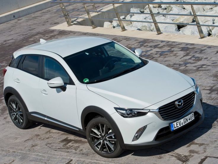 a white mazda cx - 3 parked on the street